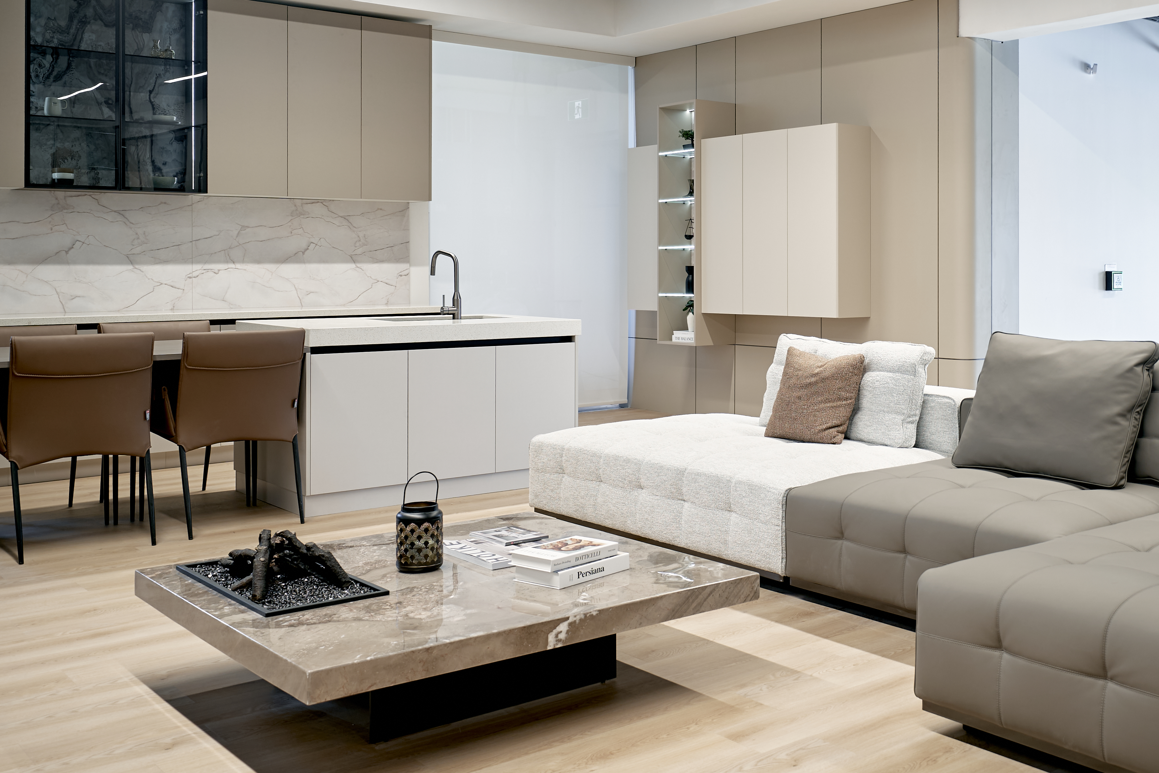 Coordinated kitchen and living millwork with warm neutral finishes