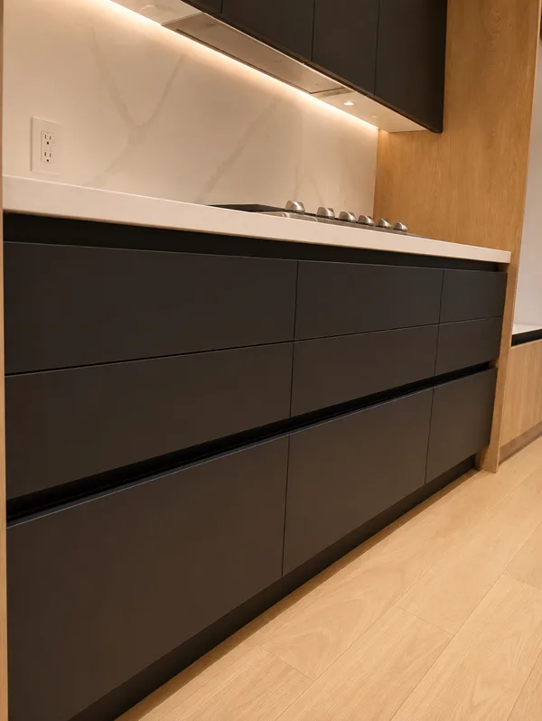Close-up of black cabinetry drawers with wood and stone finishes